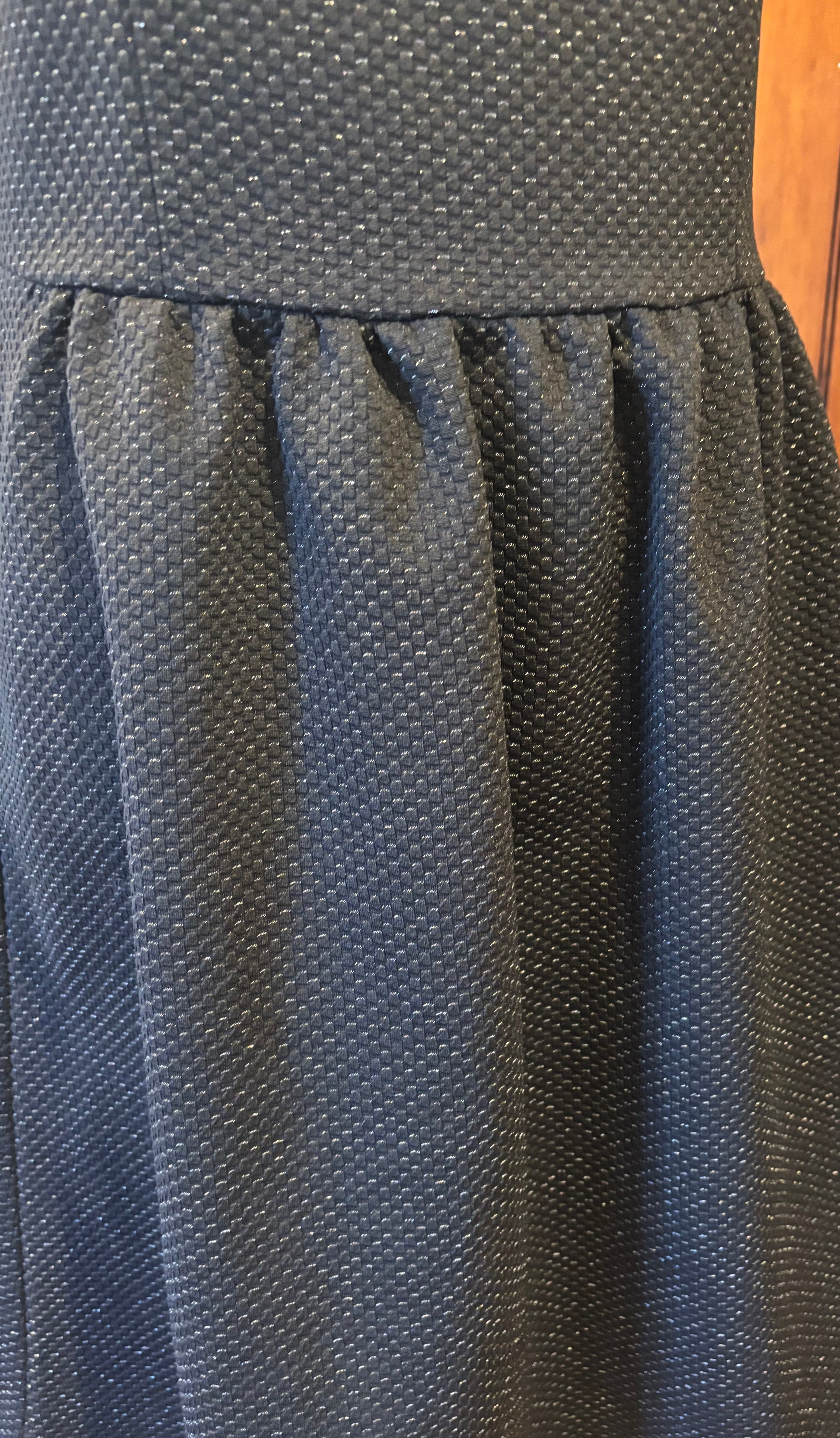 HD in Paris black sleeveless dress detail close up subtle sparkle elegant pleats defined waist Sassy and Chic