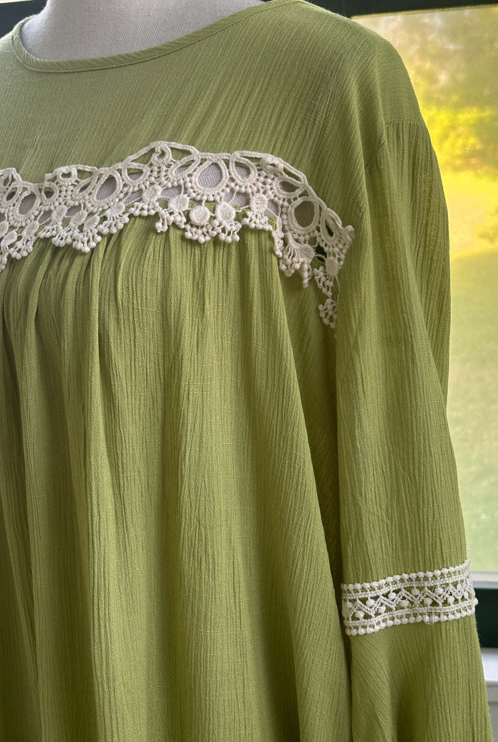Close-up of white crochet lace chest panel and sleeve trim on Hayden LA chartreuse green dress