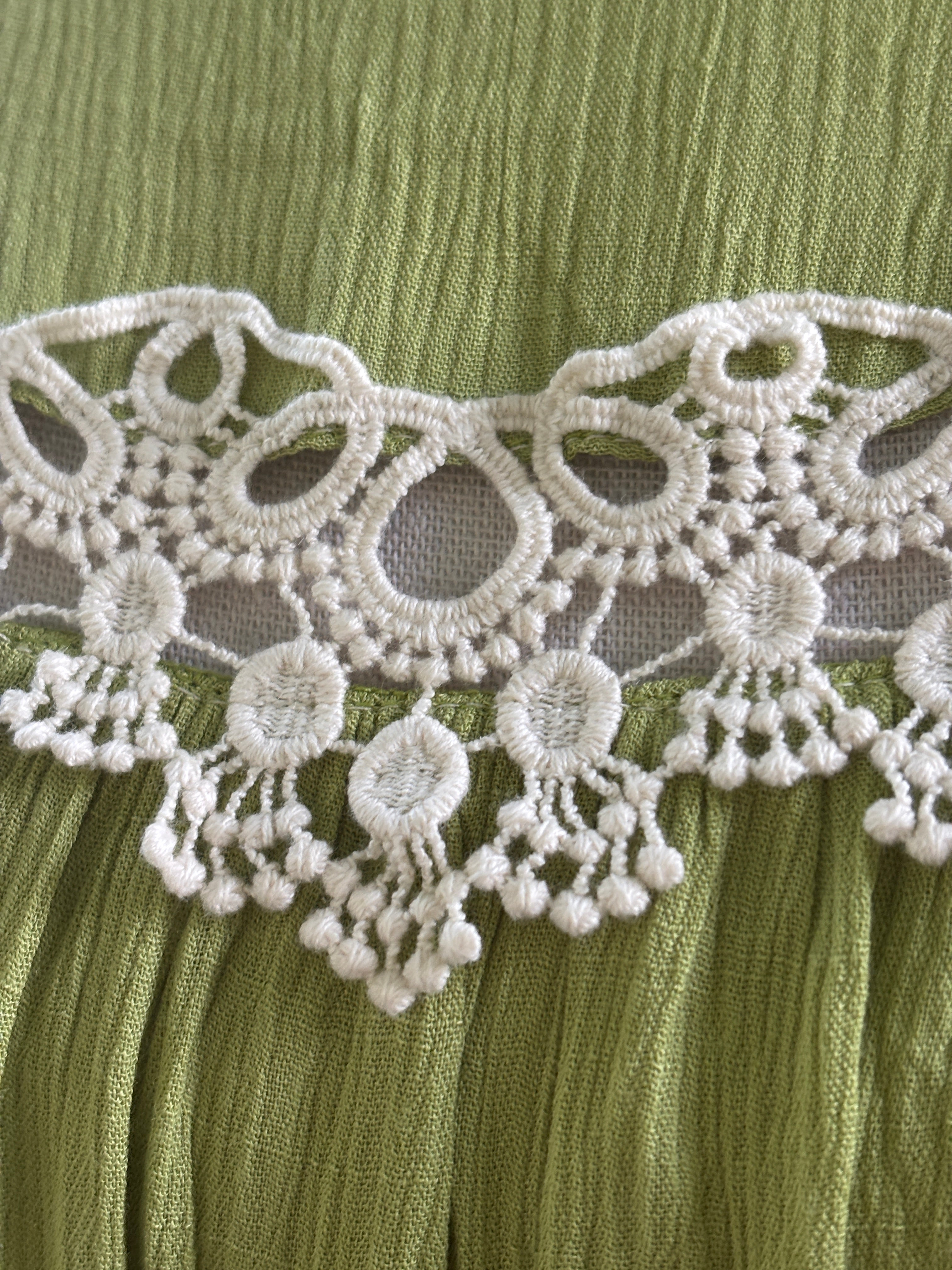 Close-up of white crochet lace medallion detail with dangling bead trim on Hayden LA dress