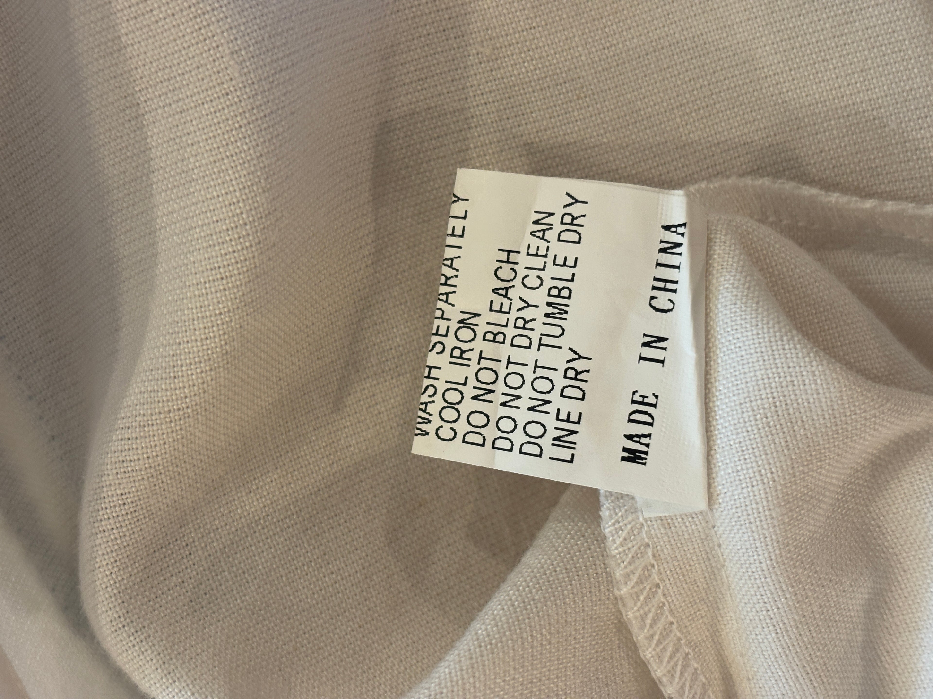 Care label for Les Canebiers white tunic dress — wash separately, line dry