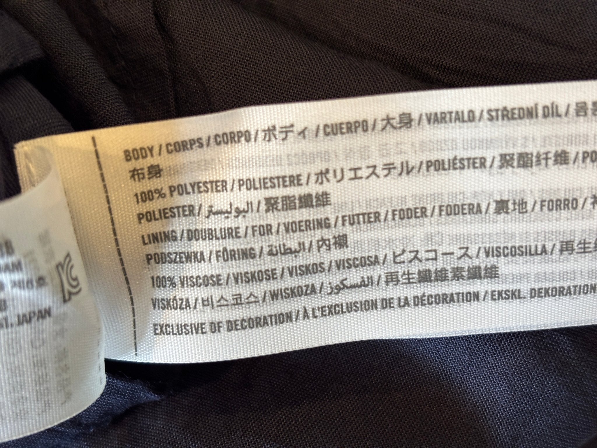 Fabric content label showing 100% polyester body and 100% viscose lining