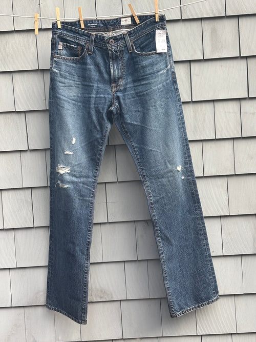 AG Adriano Goldschmied The Protégé straight leg jeans hanging on clothesline with tags