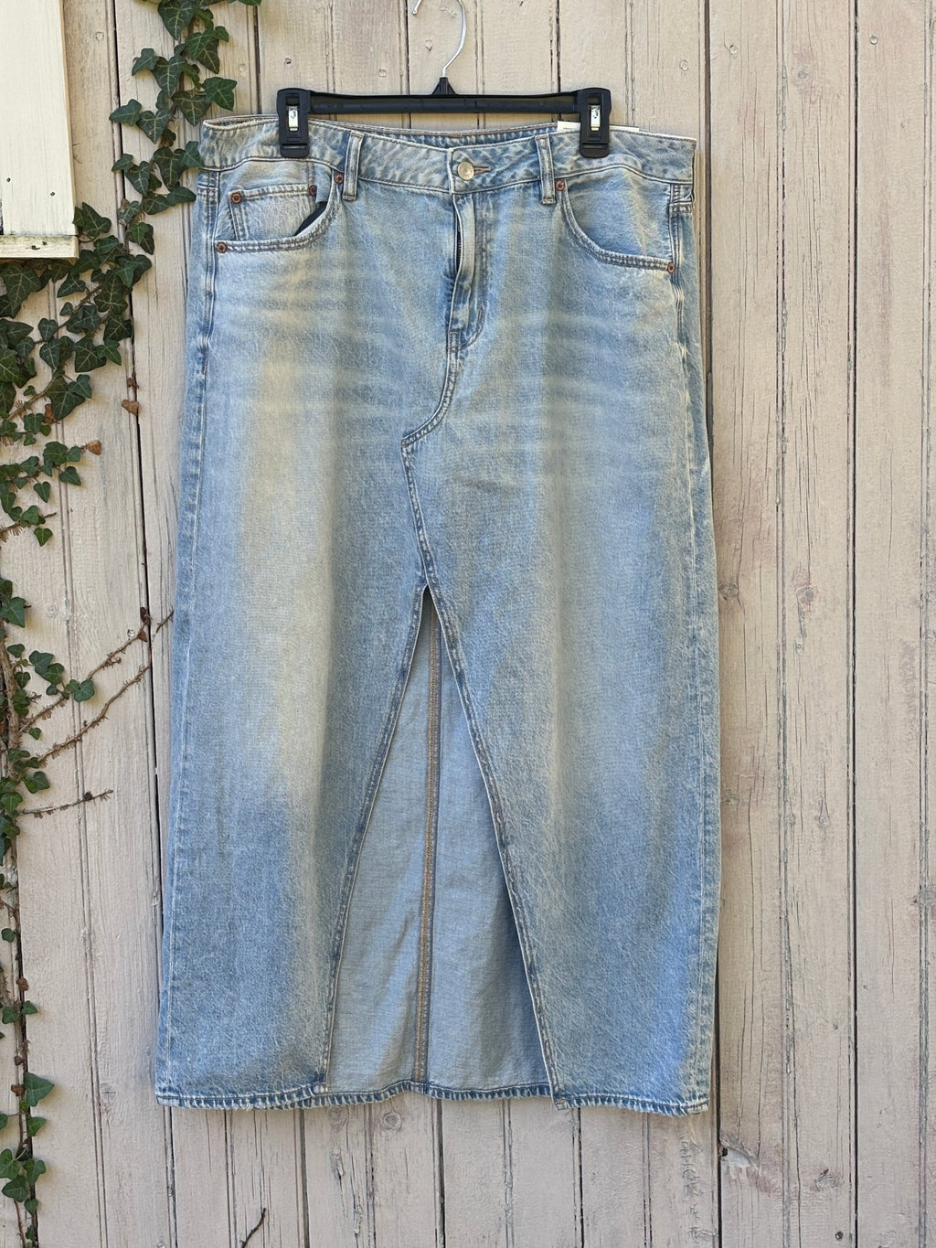 Like-new American Eagle light wash low-rise denim maxi skirt, full front view with center slit
