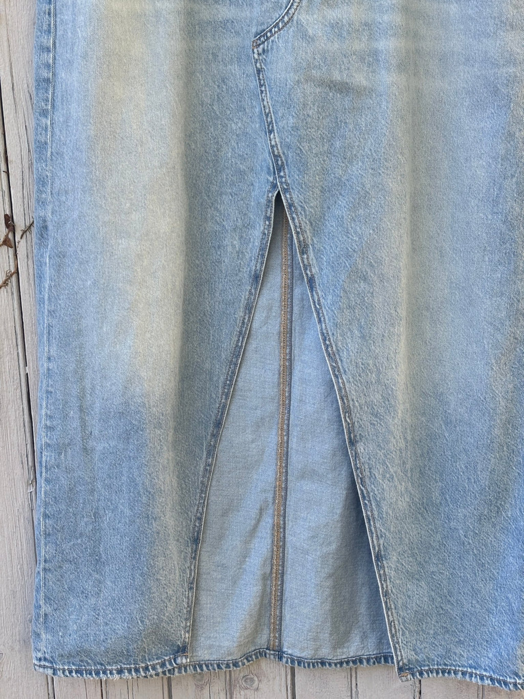 Close-up of front center slit on American Eagle light wash denim maxi skirt