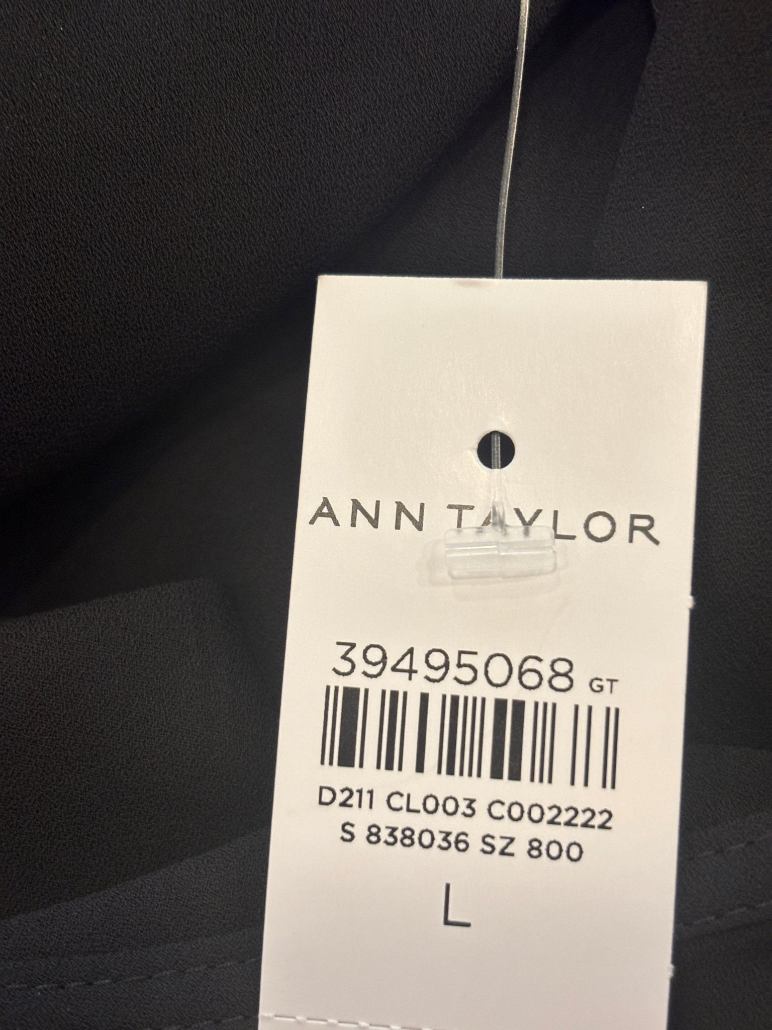Ann Taylor hang tag showing size Large on black ruffle blouse, NWT
