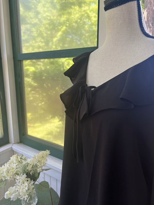 Close-up of ruffle collar and self-tie neckline detail on Ann Taylor black chiffon blouse
