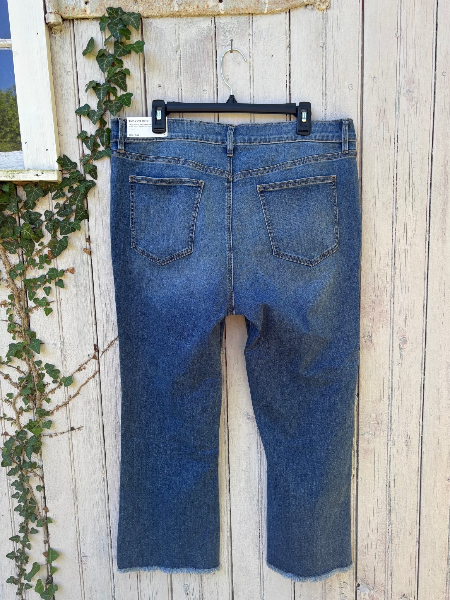 Back view of Ann Taylor Kick Crop high rise jeans showing sculpting pockets and raw frayed hem detail, size 16