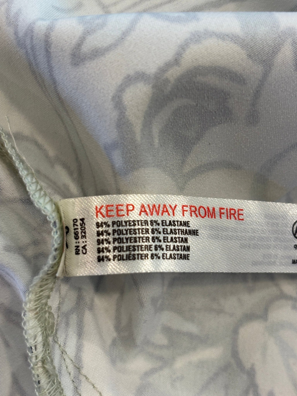 Care label showing 94% polyester 6% elastane fabric content and machine wash cold instructions