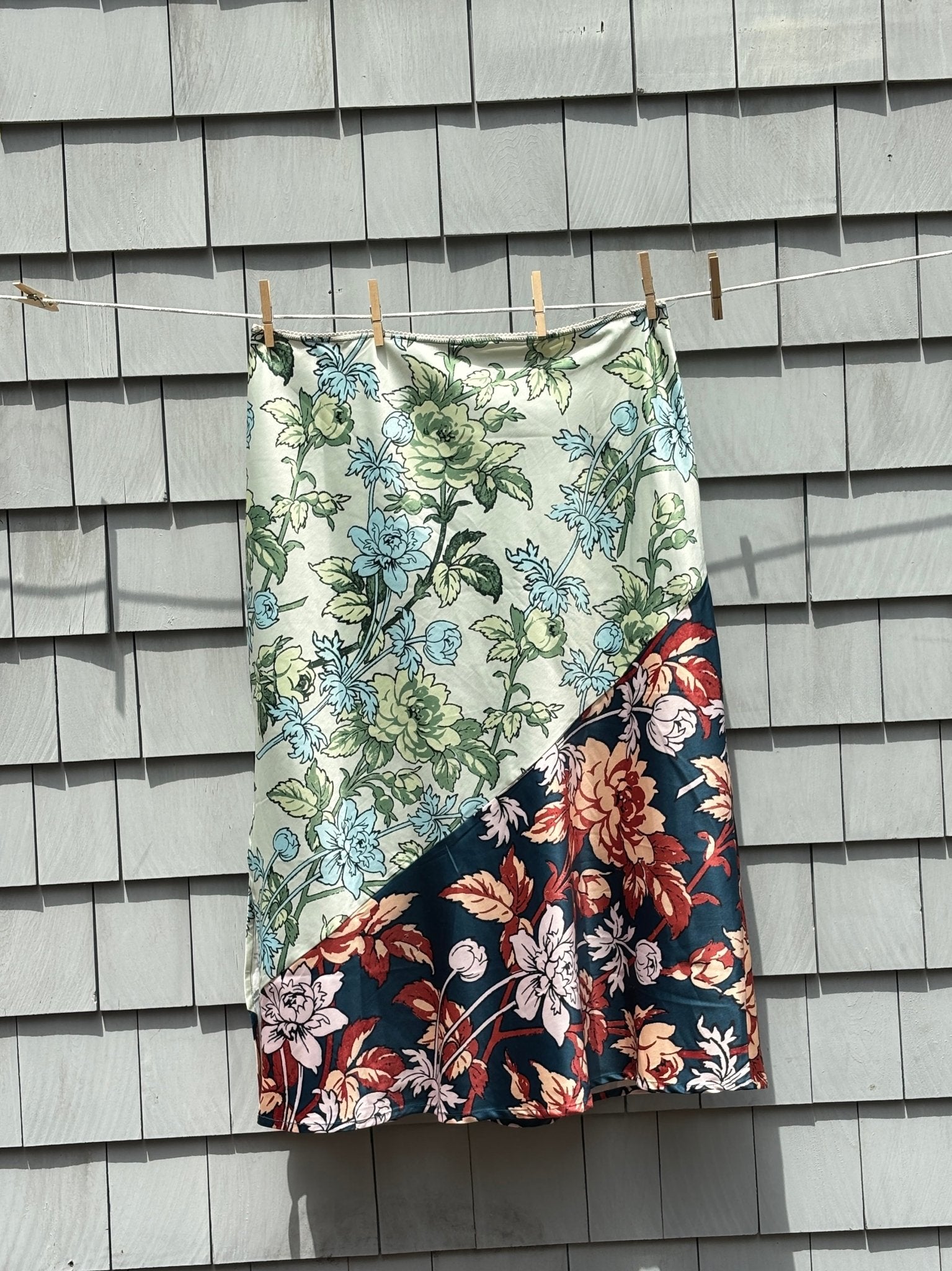 Back view of Anthropologie LyreBird floral midi skirt showing full length and colorblock diagonal seam