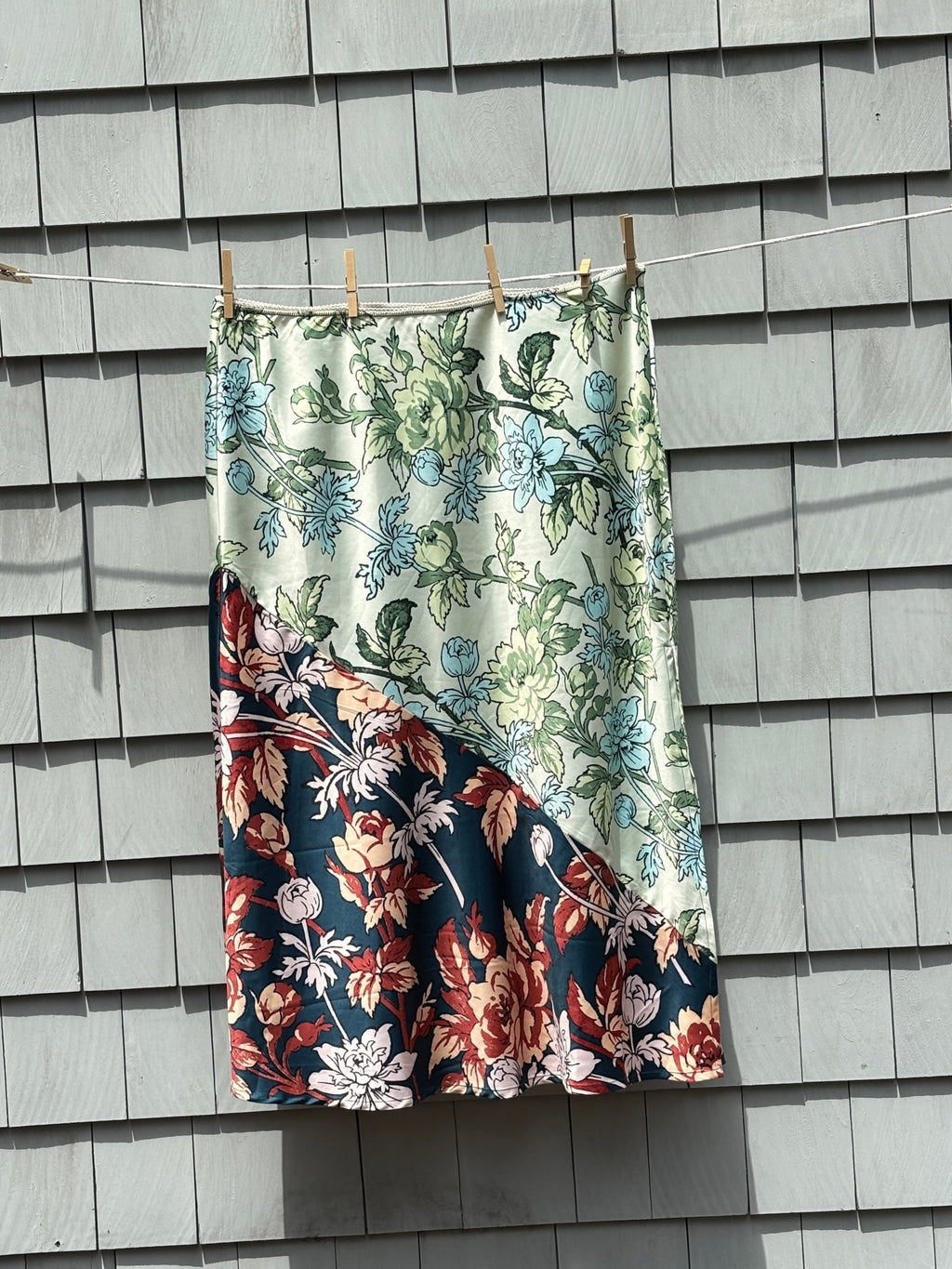 Anthropologie LyreBird Ivory Comb floral colorblock midi skirt front view showing diagonal panel with sage mint botanical and navy floral print, size XL NWT