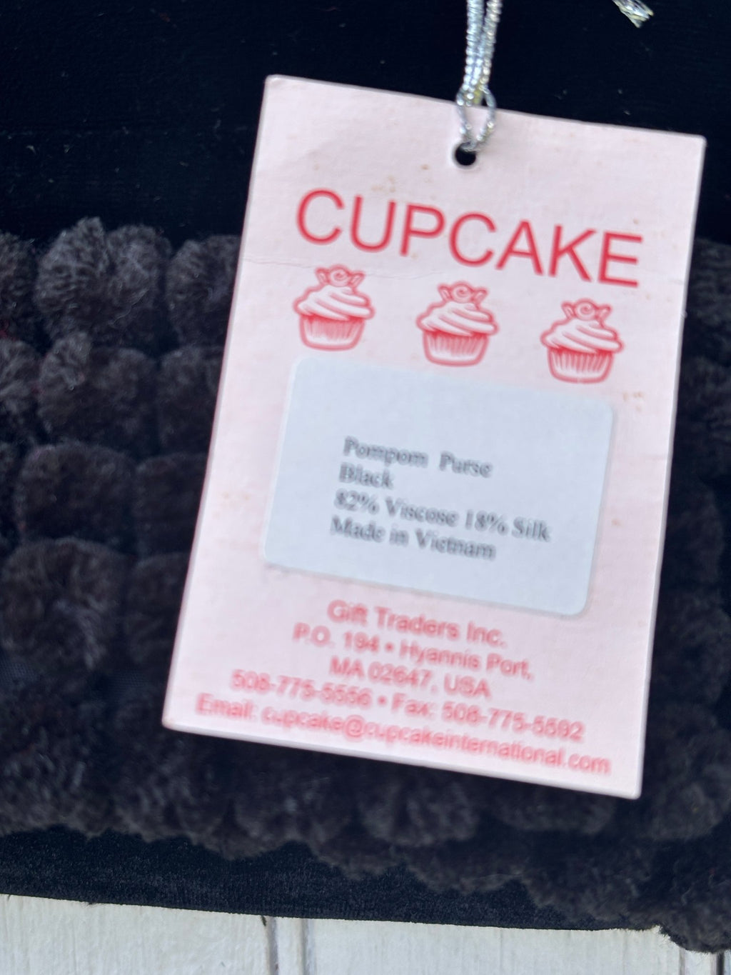 Cupcake International brand hang tag showing Pompom Purse, black, 82% viscose 18% silk, made in Vietnam