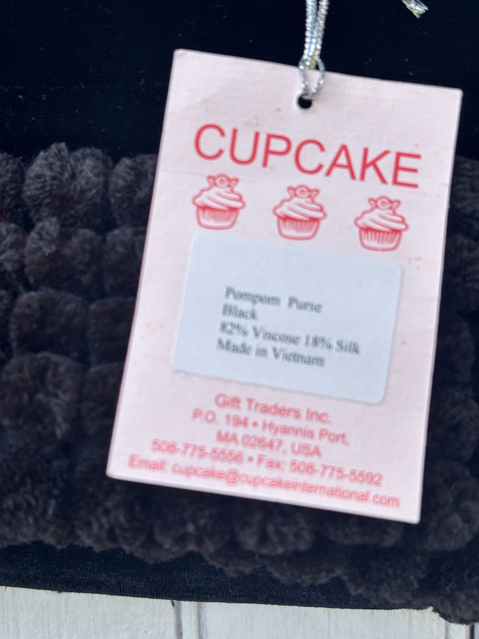 Cupcake International brand hang tag showing Pompom Purse, black, 82% viscose 18% silk, made in Vietnam