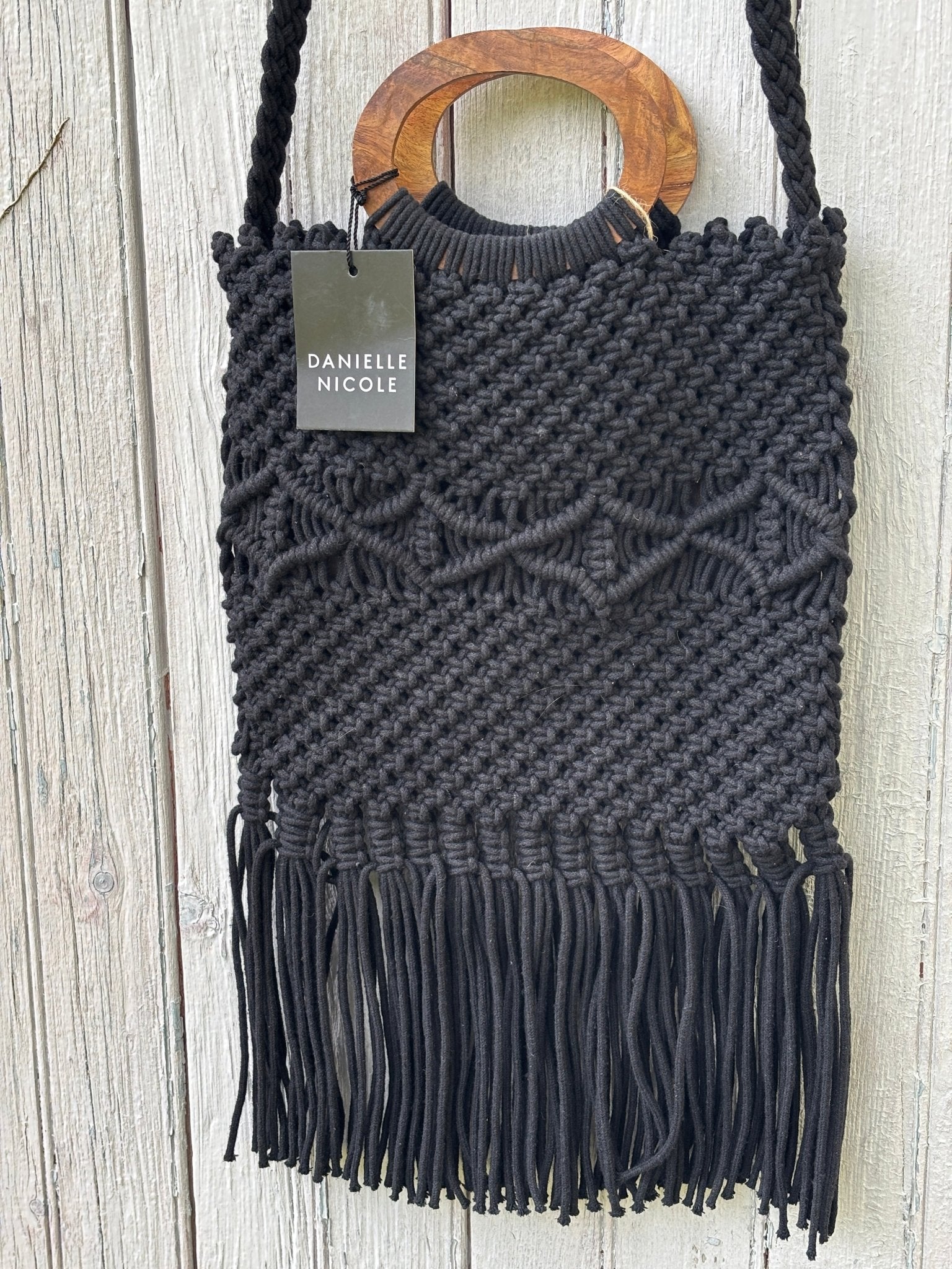 Close-up of raised geometric diamond knotwork pattern on Danielle Nicole black macramé fringe tote bag