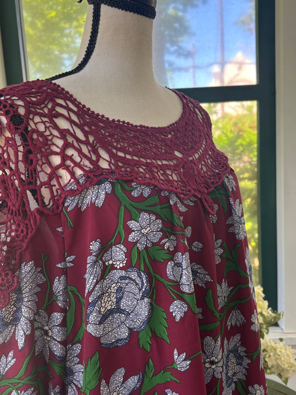 Close-up of burgundy crochet lace yoke and scoop neckline on Entro floral mini dress