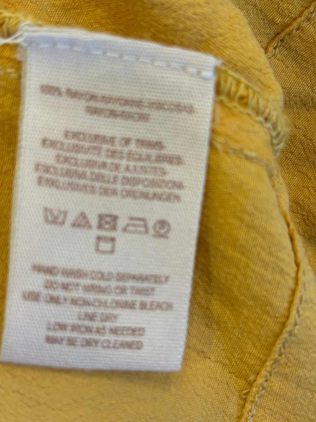 Care label showing 100% rayon, hand wash cold, line dry, may be dry cleaned