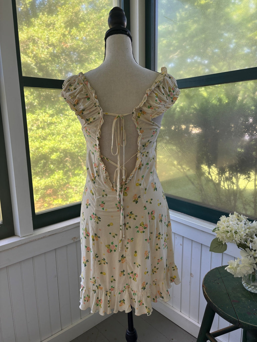 Back view showing open lace-up tie back detail and ruffle cap sleeves