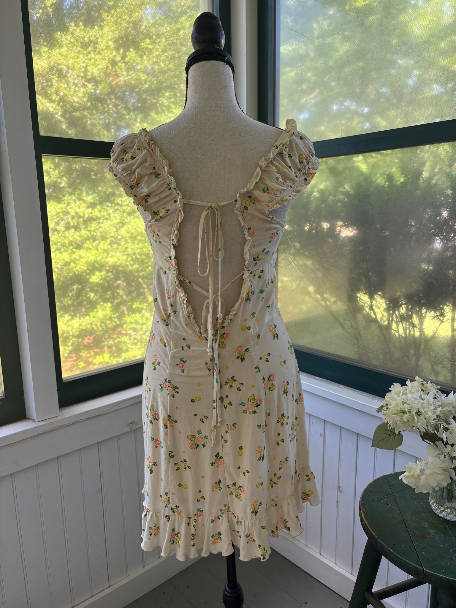 Back view showing open lace-up tie back detail and ruffle cap sleeves
