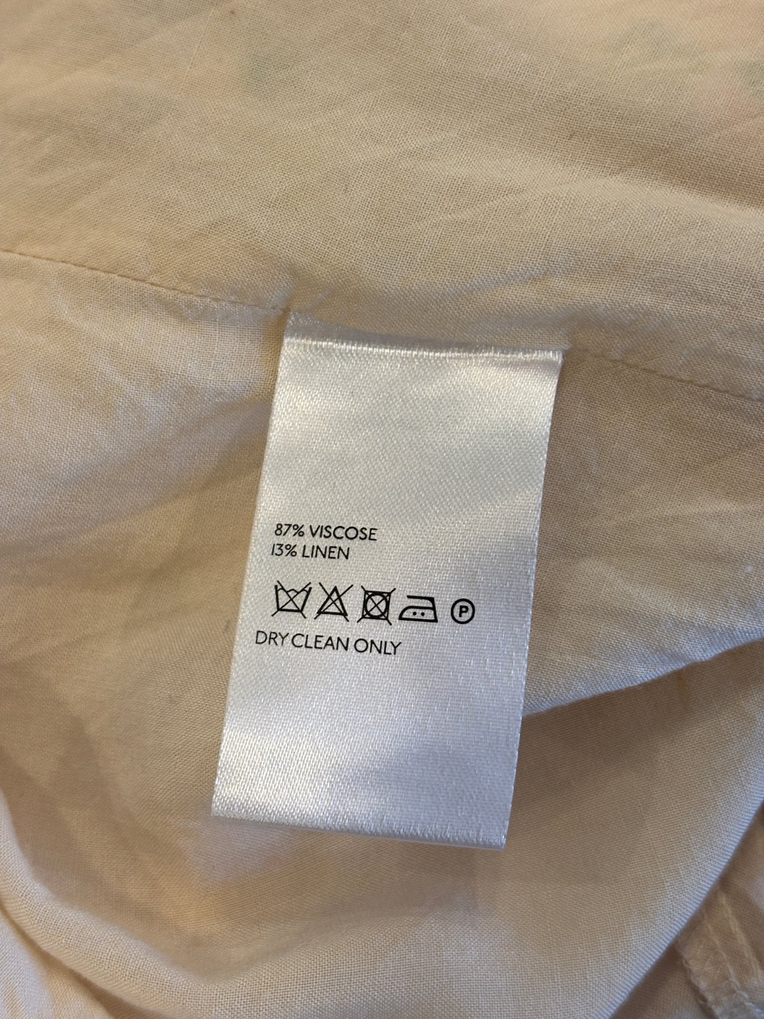 Second care label showing 87% viscose 13% linen, dry clean only symbol