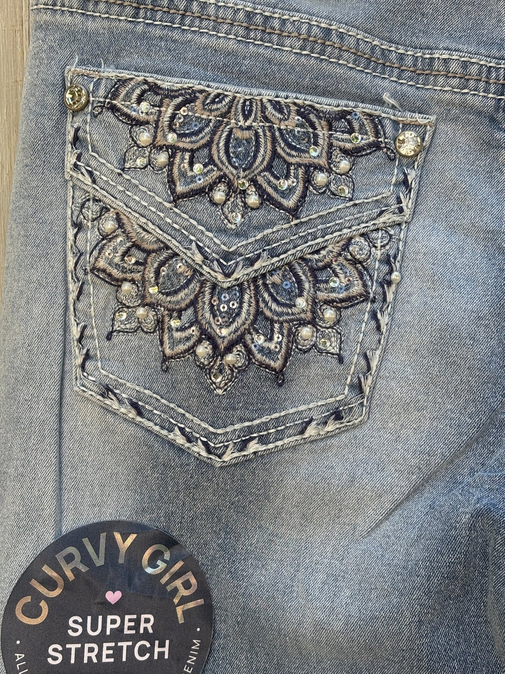 Close-up of right back pocket showing detailed mandala embroidery with rhinestones, pearls, and sequin accents