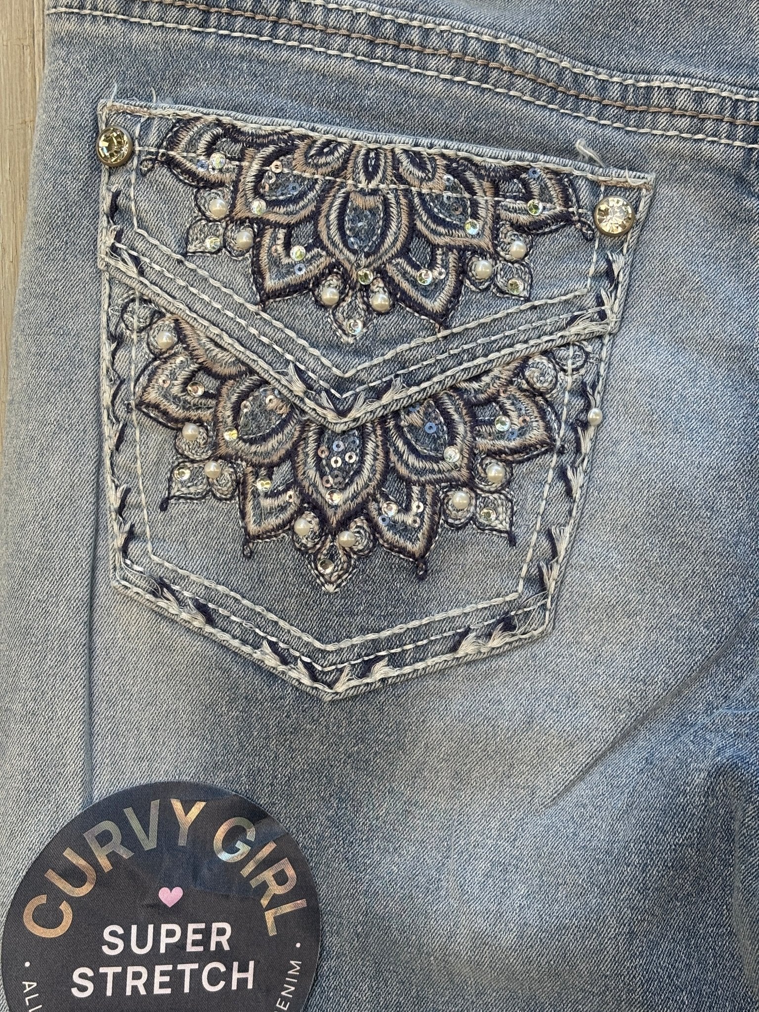 Close-up of right back pocket showing detailed mandala embroidery with rhinestones, pearls, and sequin accents
