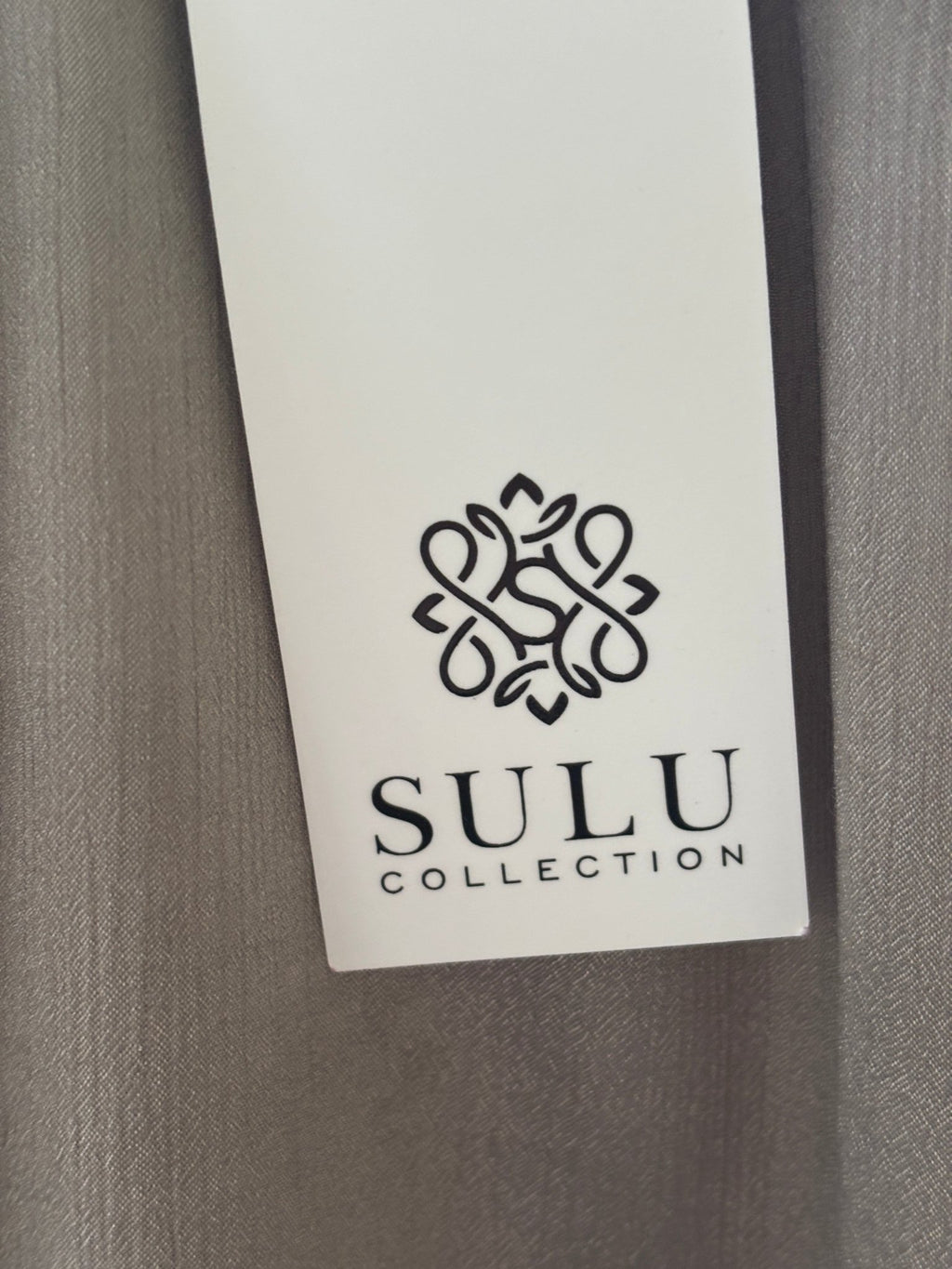 Care label showing 33% Silk 67% Polyester dry clean only for Grids by Sulu Collection taupe beaded tunic dress