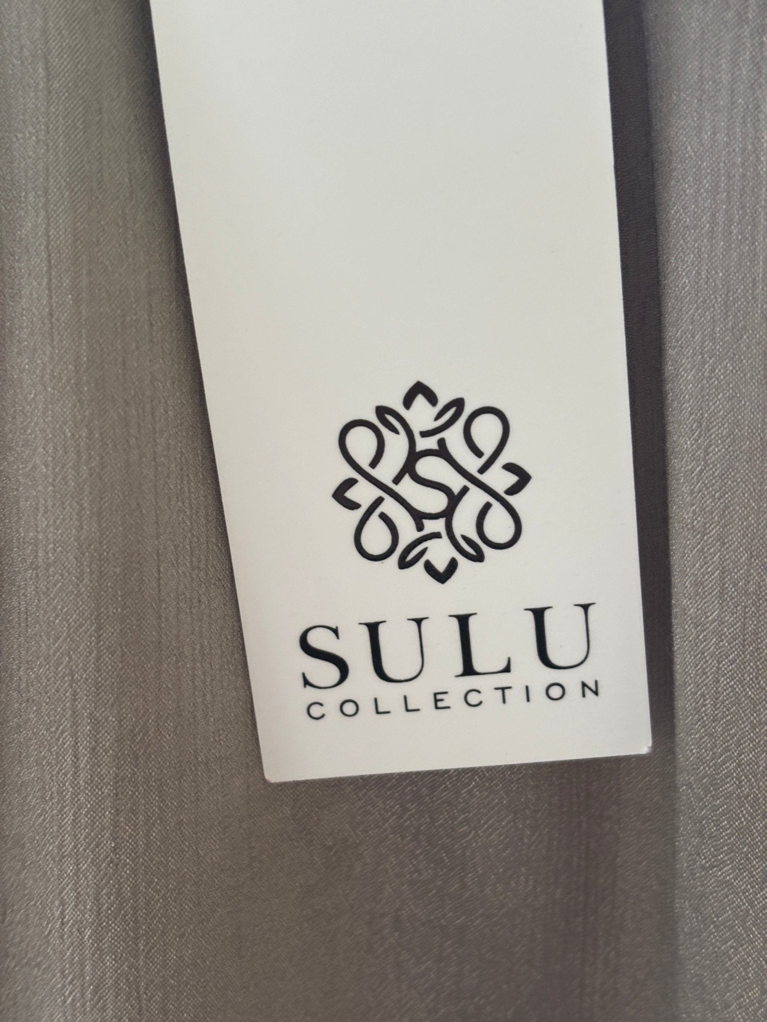 Care label showing 33% Silk 67% Polyester dry clean only for Grids by Sulu Collection taupe beaded tunic dress