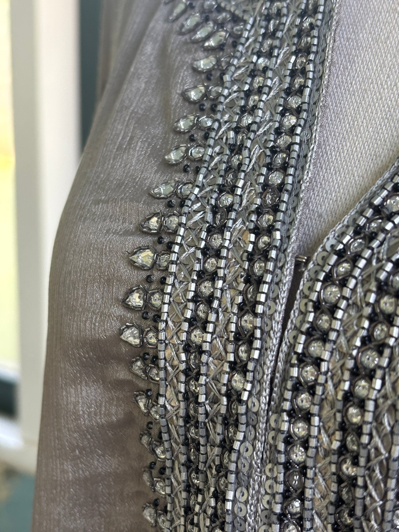 Close-up of dense rhinestone, bugle bead and silver sequin neckline embellishment on taupe silk-blend tunic dress by Grids by Sulu Collection