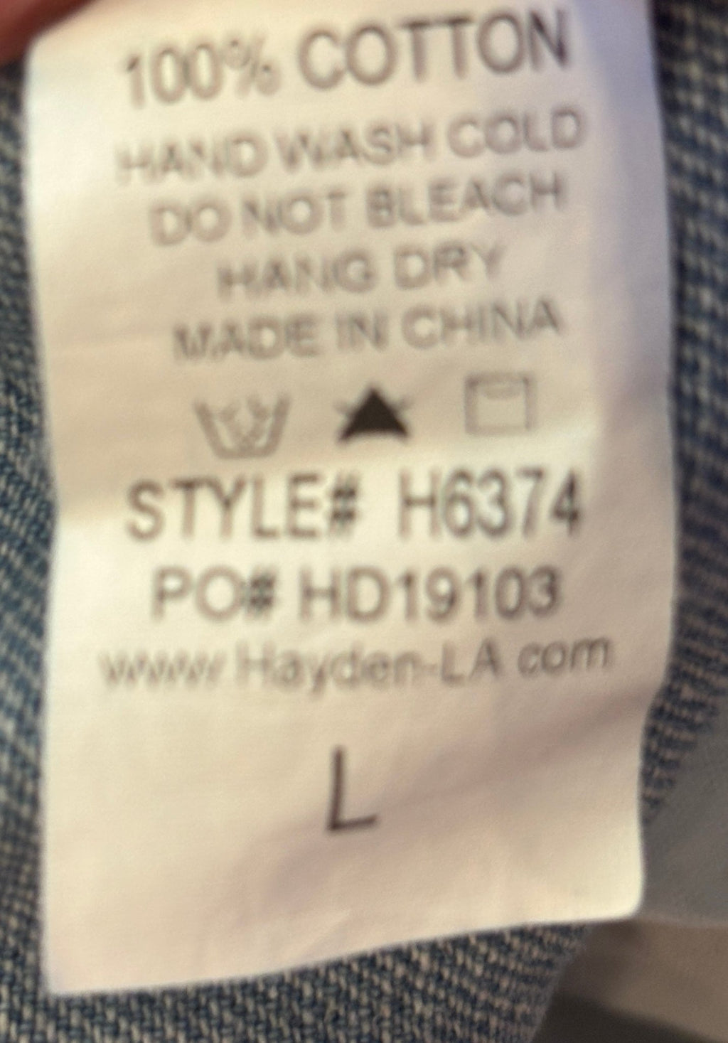 Care label showing 100% Cotton hand wash cold for Hayden Los Angeles light wash denim wrap mini skirt