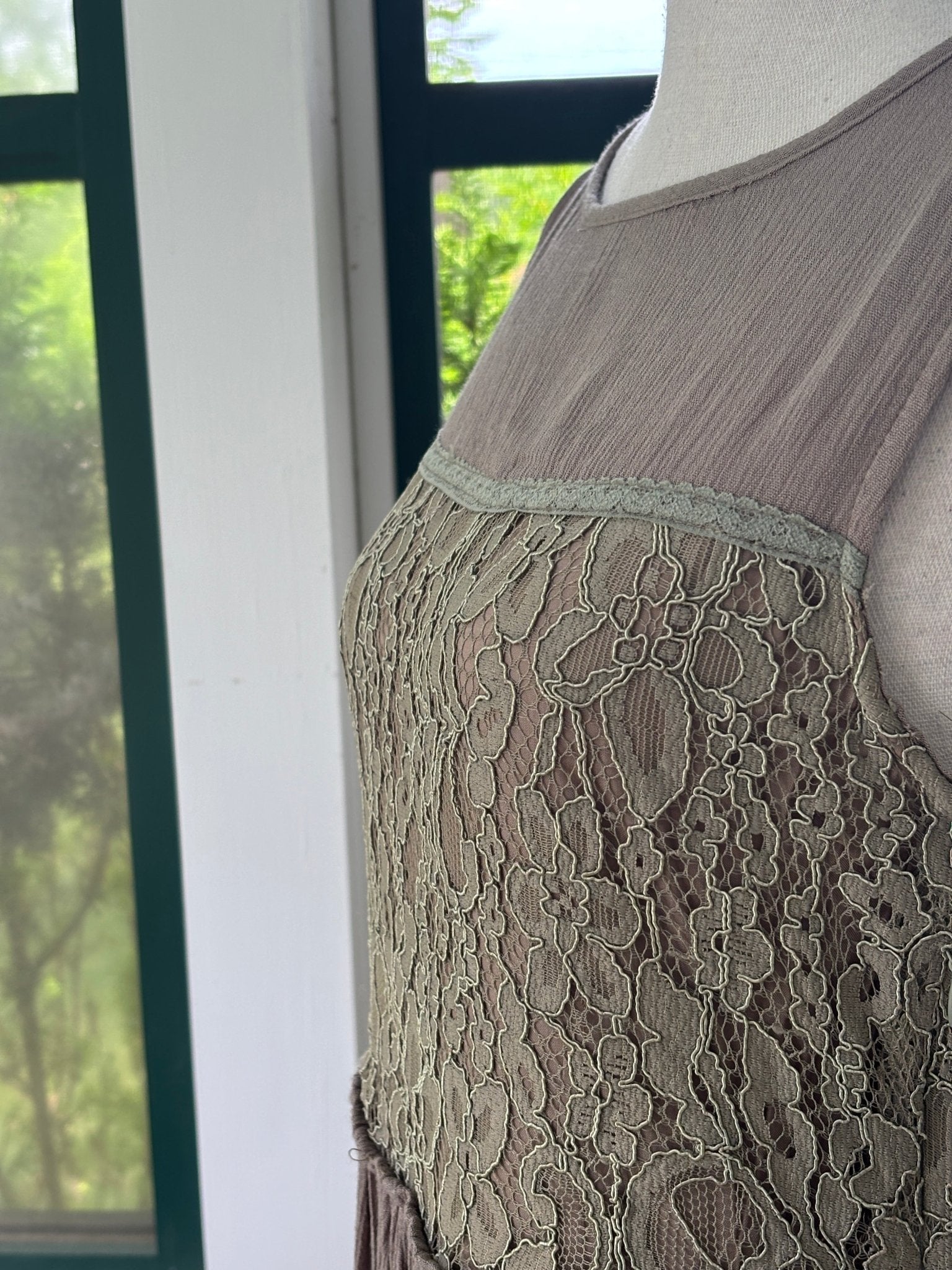 Close-up of sage green floral lace bodice panel and lace trim detail on Hayden LA taupe drop waist dress
