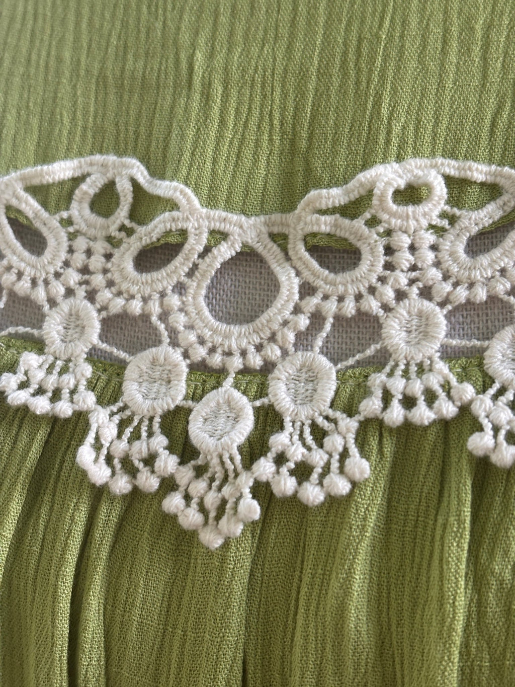 Close-up of white crochet lace medallion detail with dangling bead trim on Hayden LA dress
