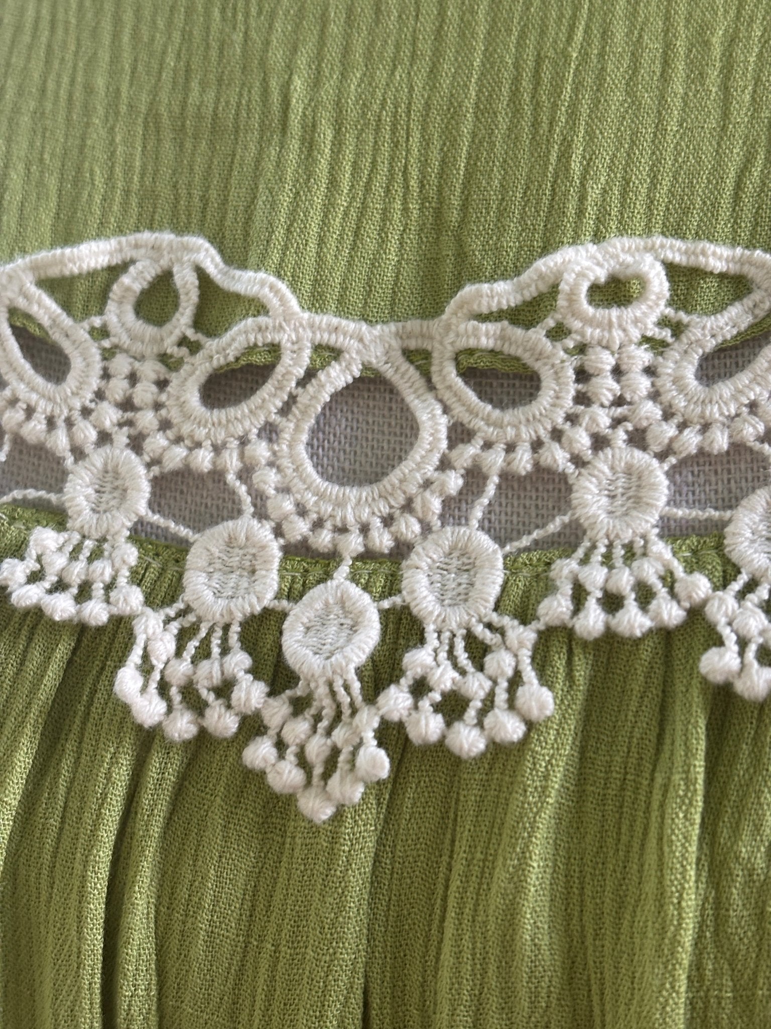 Close-up of white crochet lace medallion detail with dangling bead trim on Hayden LA dress