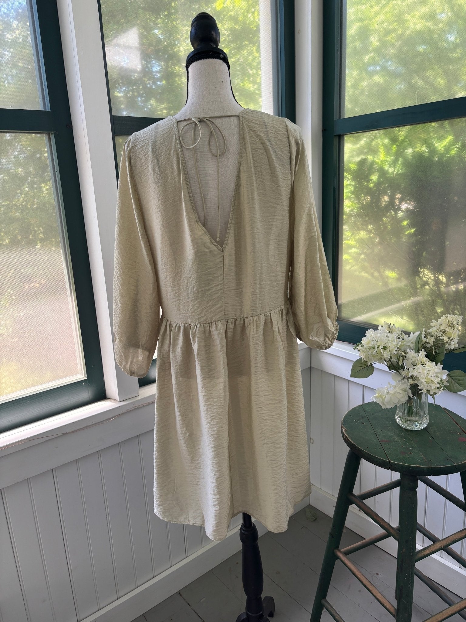 Back view of H&M Conscious midi dress showing open V back with self-tie closure and full A-line skirt