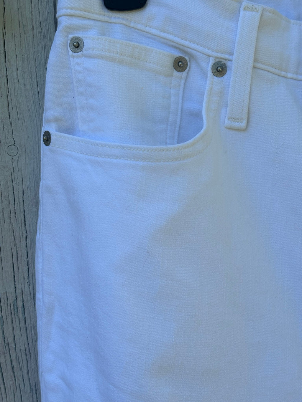 Close-up of front pocket and antique silver hardware detail on J.Crew white curvy demi boot jeans