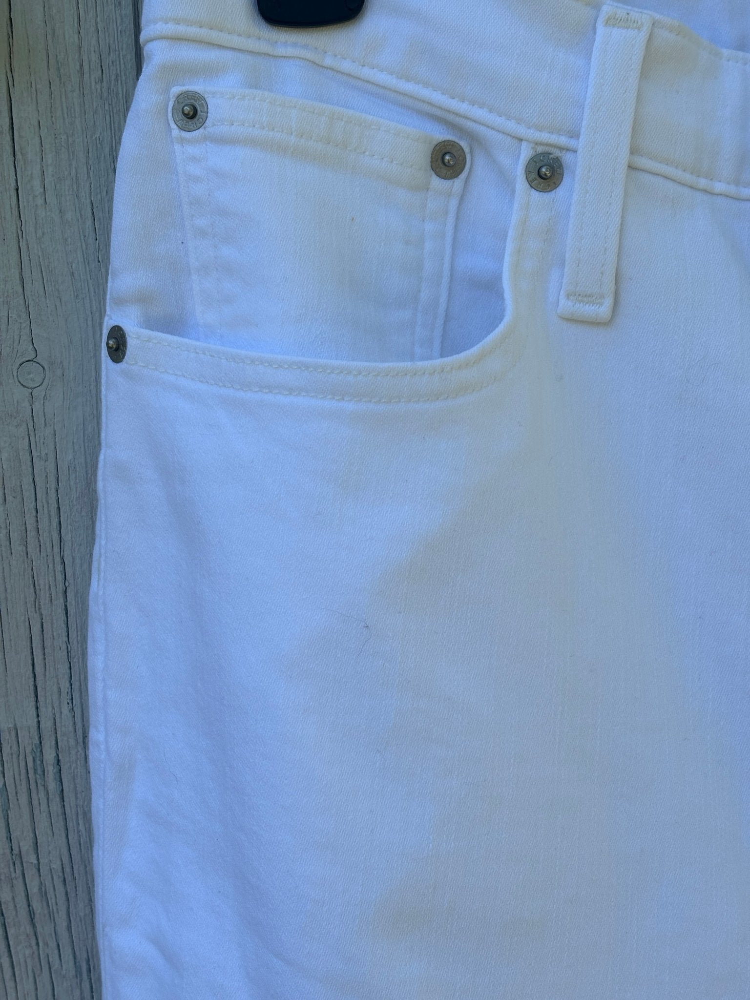 Close-up of front pocket and antique silver hardware detail on J.Crew white curvy demi boot jeans