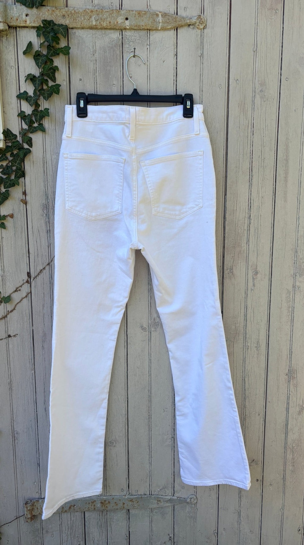 Back view of J.Crew white curvy demi boot jeans showing Perfecting Pockets and full-length flared leg