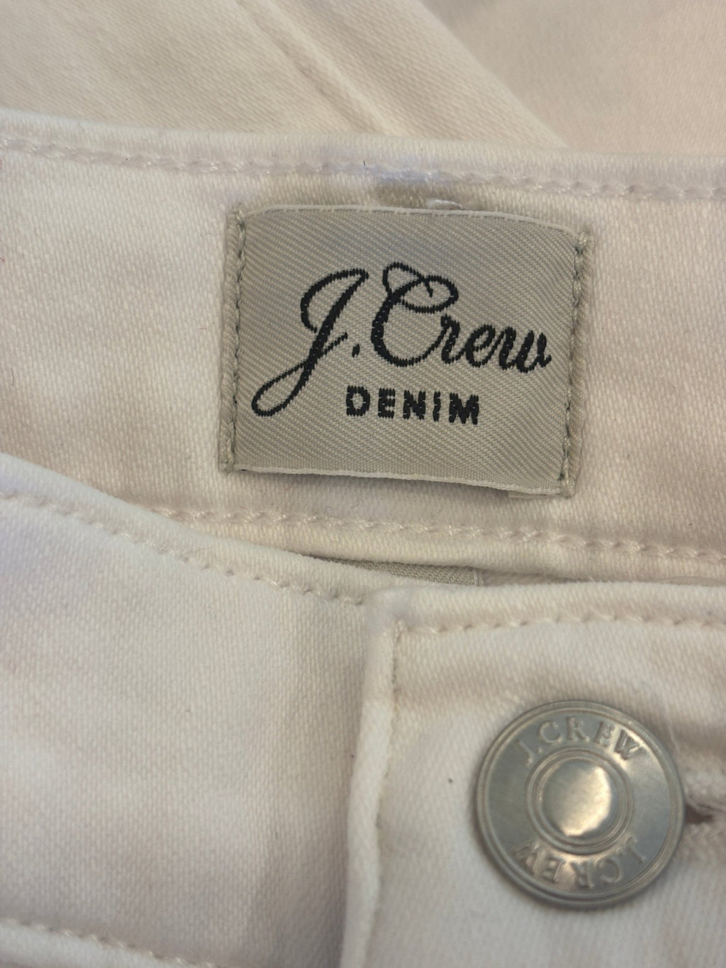 J.Crew Denim brand label with silver button detail inside white curvy demi boot jeans