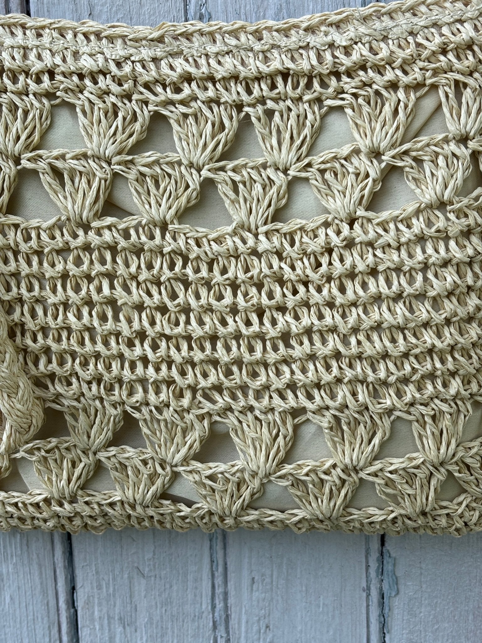 Close-up of open floral crochet weave pattern and fabric lining on Kaleidoscope natural ivory crossbody bag