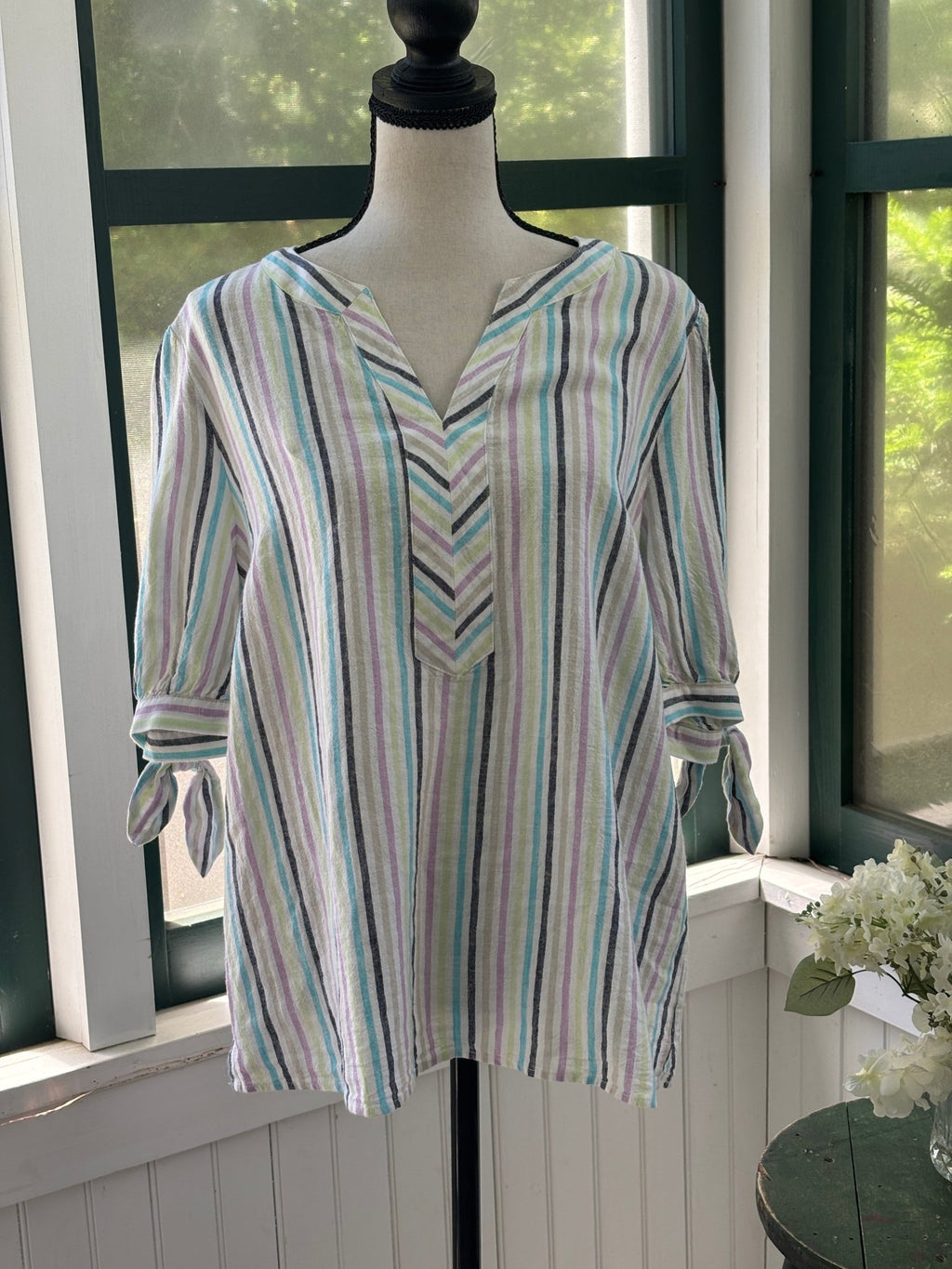 Front view of Kim Rogers multi-stripe linen tunic top on dress form, split V-neckline and 3/4 tie-knot cuff sleeves visible