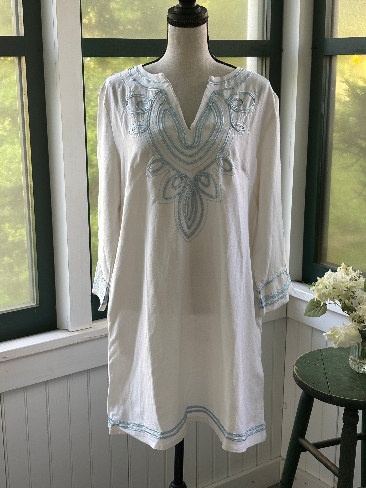 Les Canebiers white embroidered tunic dress on mannequin, split V-neckline with sky blue scrolling medallion embroidery at chest