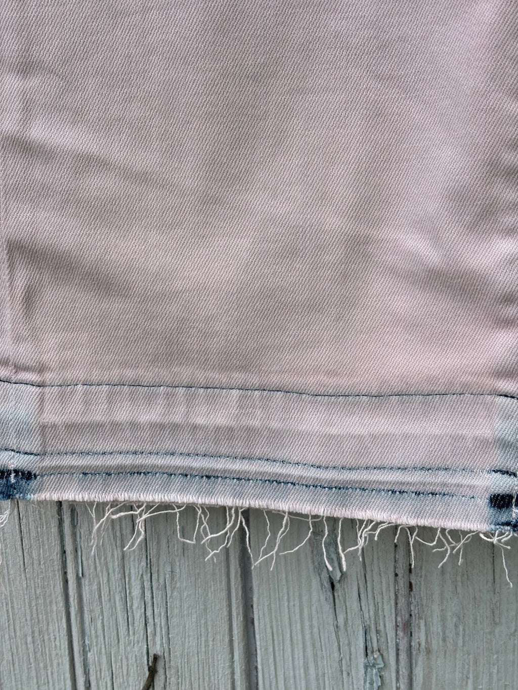 Detail shot of raw frayed hem and contrast stitching on LOFT The Crop jeans in blush pink