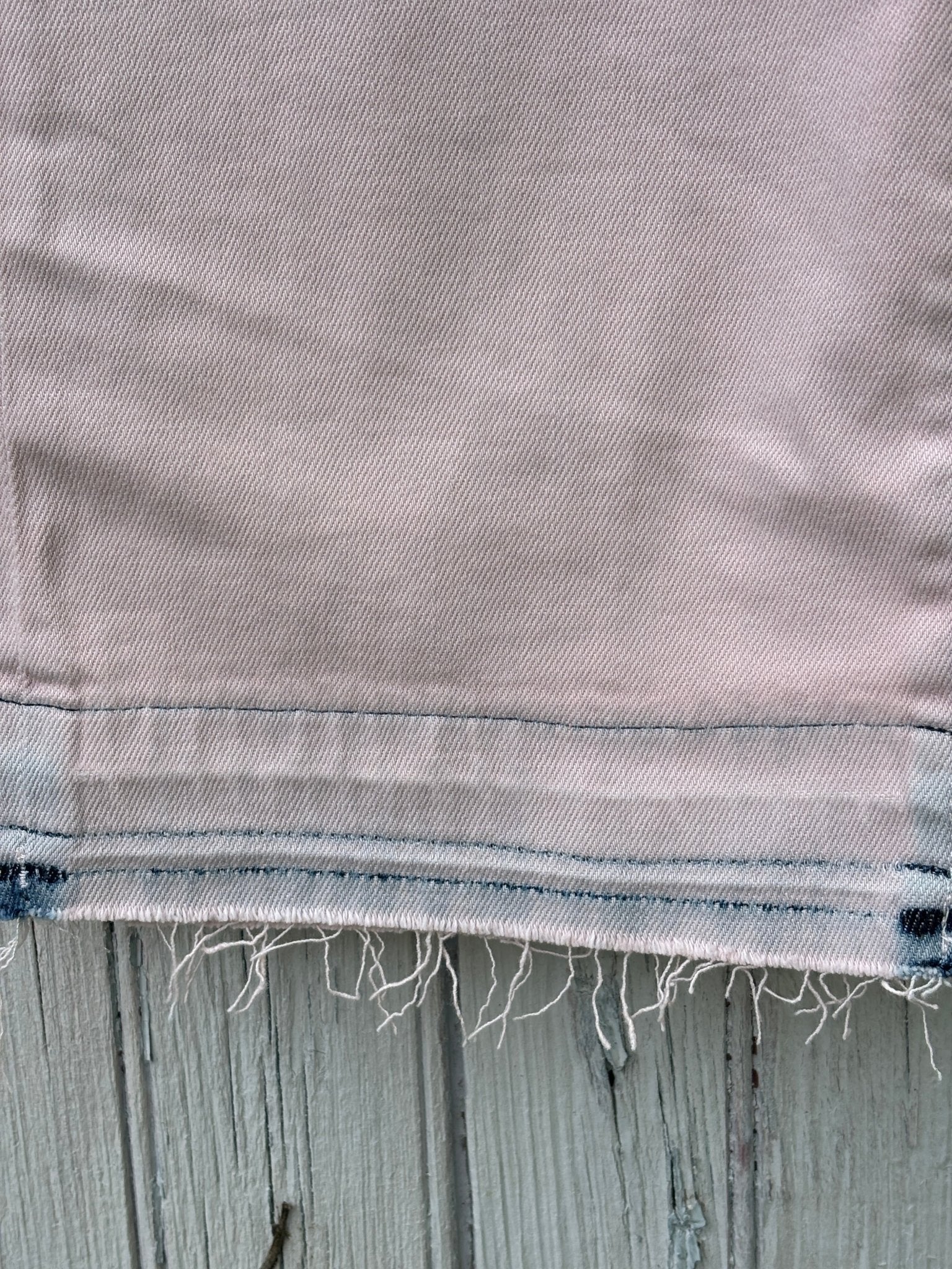 Detail shot of raw frayed hem and contrast stitching on LOFT The Crop jeans in blush pink