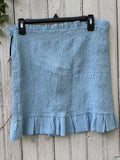 Lovers + Friends sky blue smocked mini skirt with ruffle hem, front view on hanger
