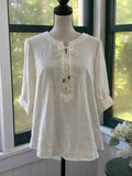 Maeve by Anthropologie ivory linen lace-up top on mannequin, relaxed A-line silhouette with roll-tab sleeves, size 6 NWT