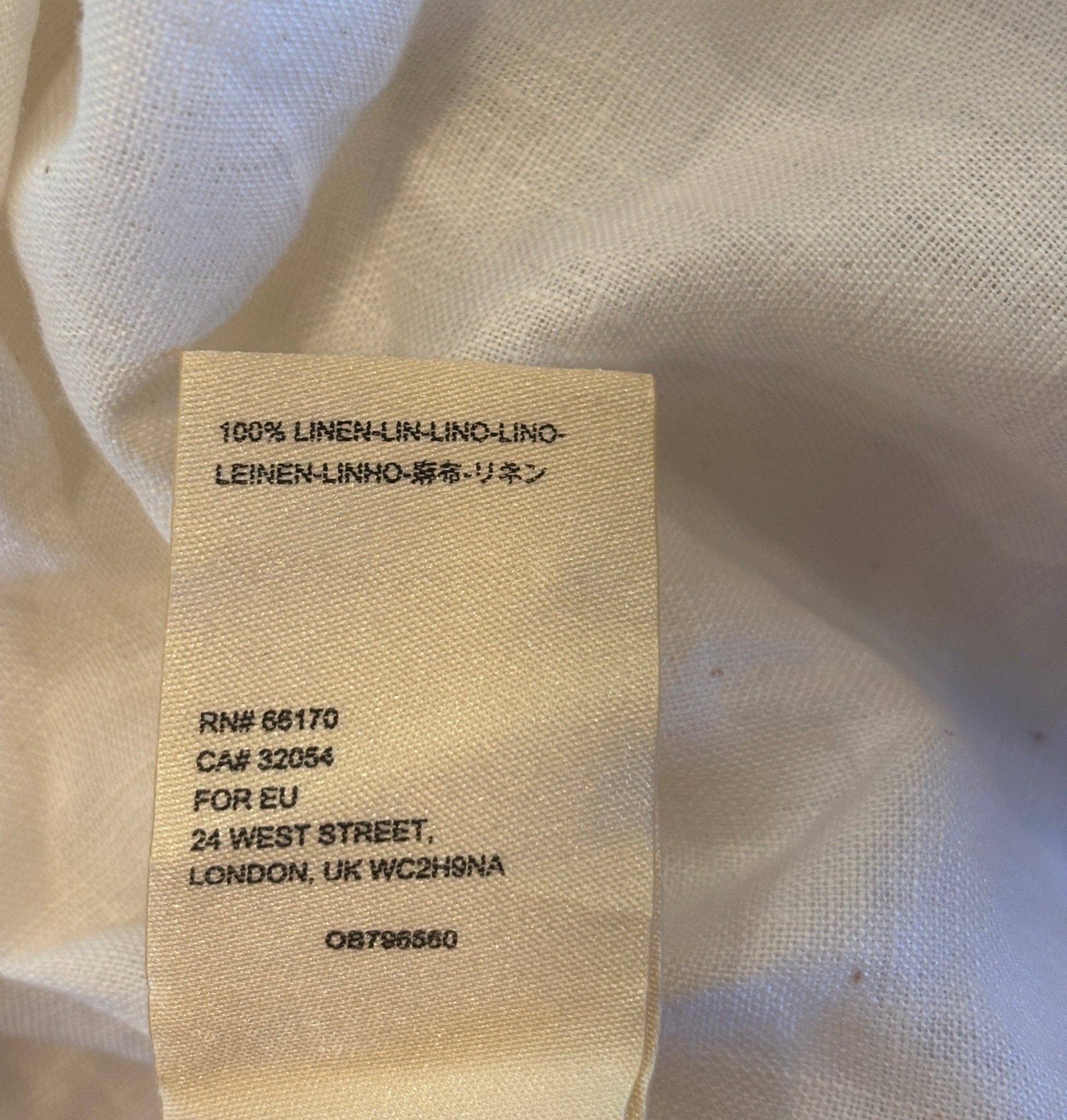 Fabric content label showing 100% linen for Maeve by Anthropologie ivory lace-up top