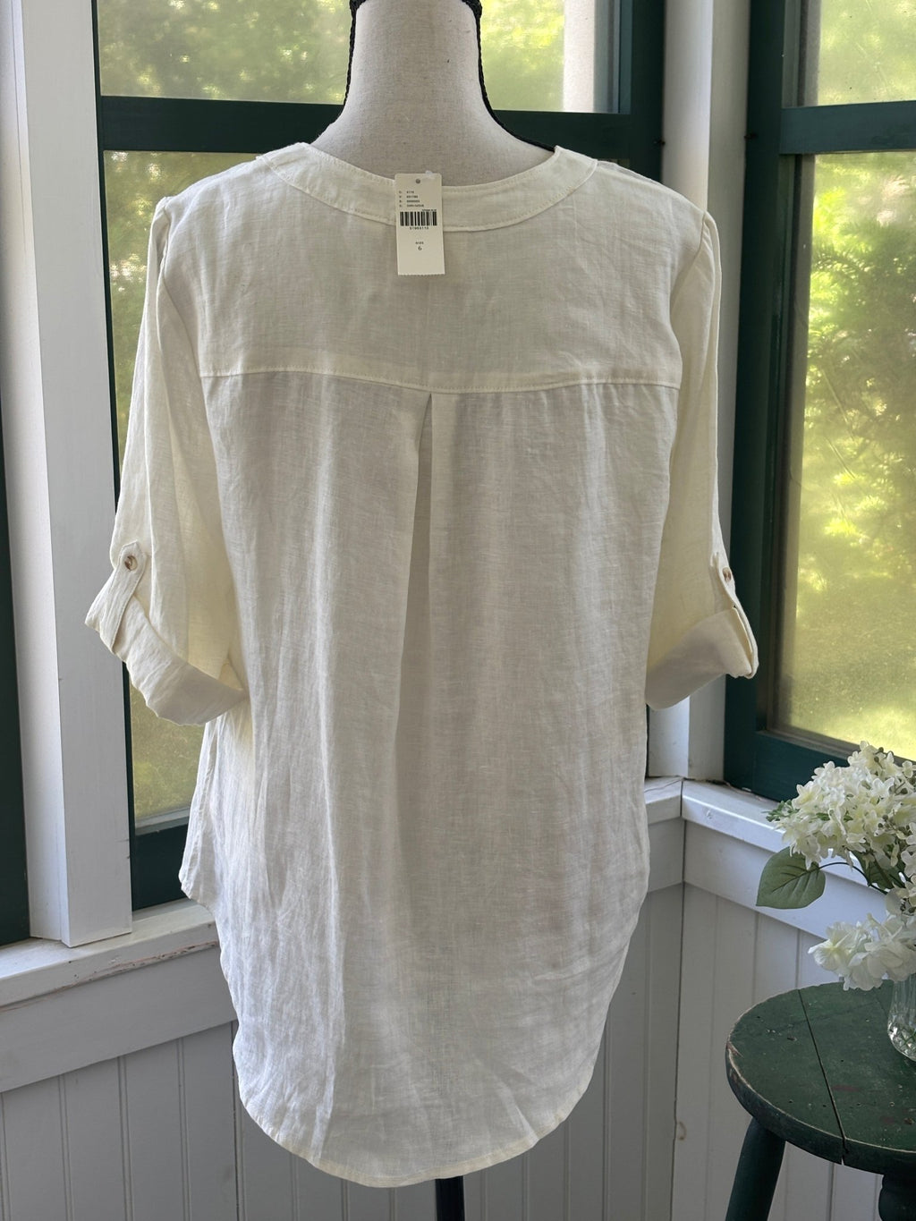 Back view of Maeve by Anthropologie ivory linen lace-up top showing center back pleat and roll-tab sleeve detail