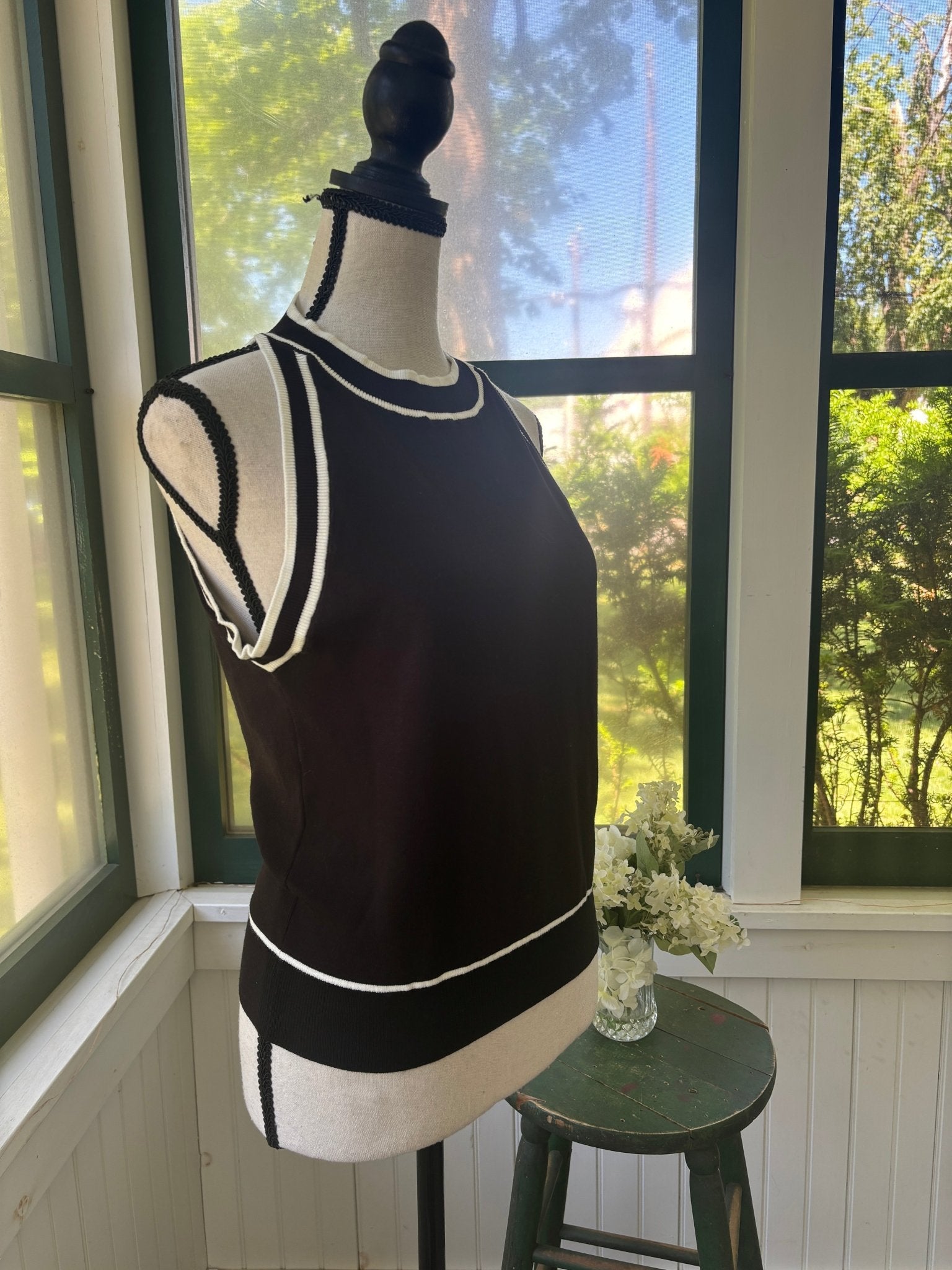 Miholl black knit tank top side view showing white contrast trim at armhole and hem detail