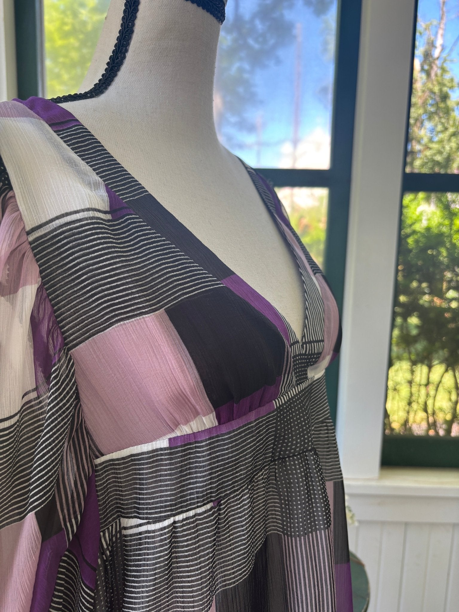 Close-up of deep V-neckline and smocked empire waist on Miss Sixty geometric print dress