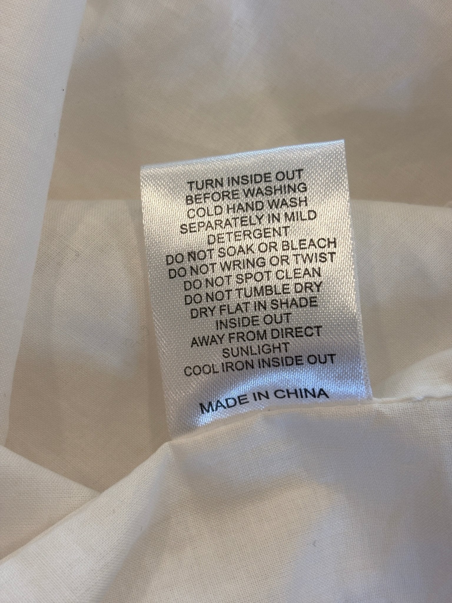 Care instructions label for Sabo Luxe Tamzyn midi skirt, made in China