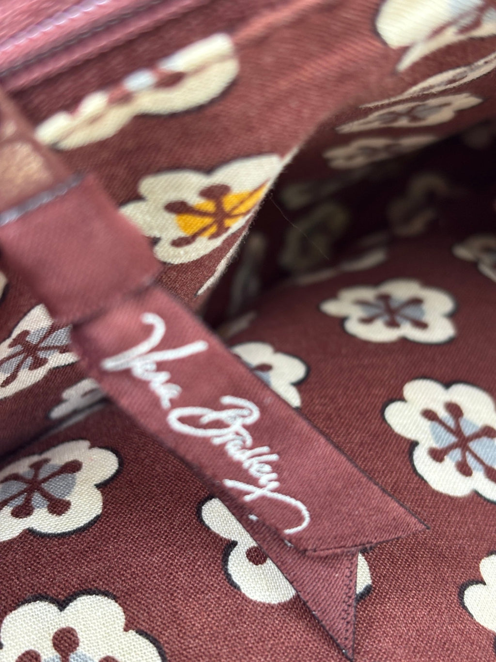 Vera Bradley brand label inside coordinating floral print interior of brown patchwork quilted shoulder bag