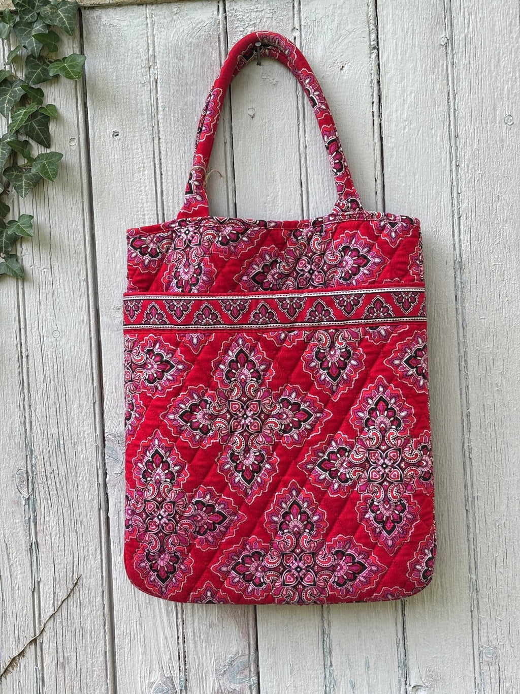 Vera Bradley red medallion quilted cotton tote bag hanging on fence, crimson red with pink and black medallion print, like new